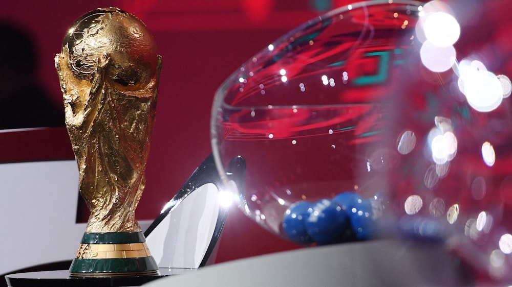 Der WM-Pokal steht bei der Auslosung neben einer Lostrommel.