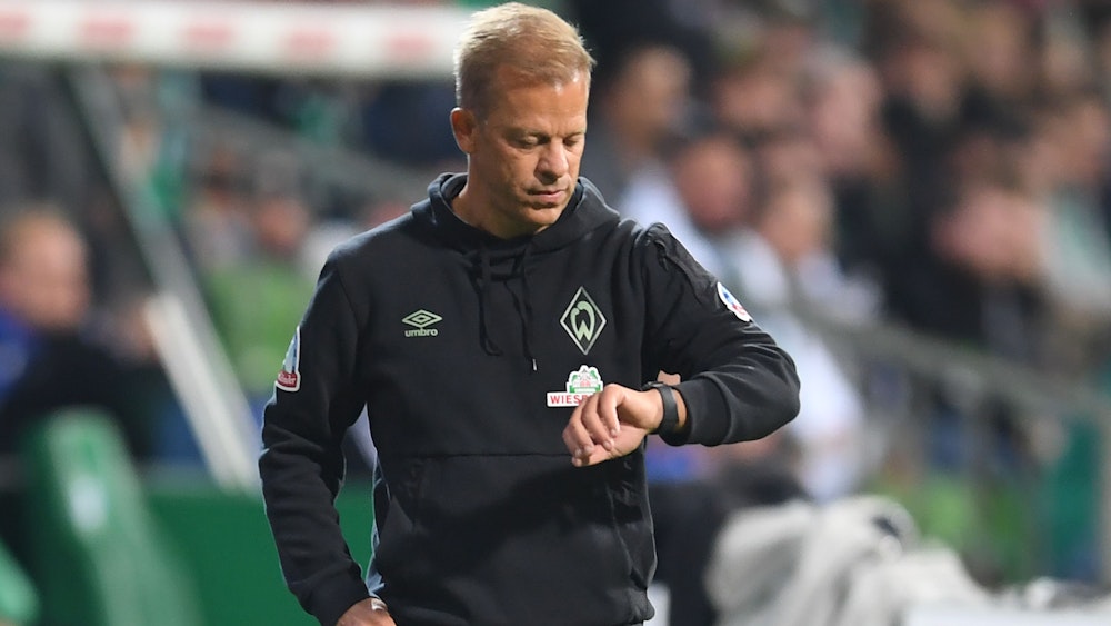 Werders ehemaliger Trainer Markus Anfang schaut an der Seitenlinie auf die Uhr.