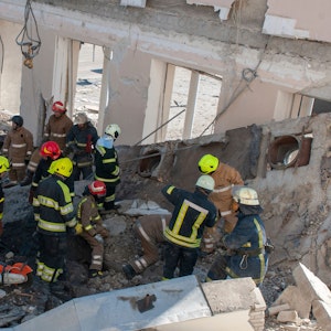 Rettungskräfte arbeiten inmitten von Trümmern eines zerstörten Gebäudes in Charkiw.