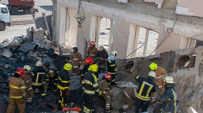 Rettungskräfte arbeiten inmitten von Trümmern eines zerstörten Gebäudes in Charkiw.