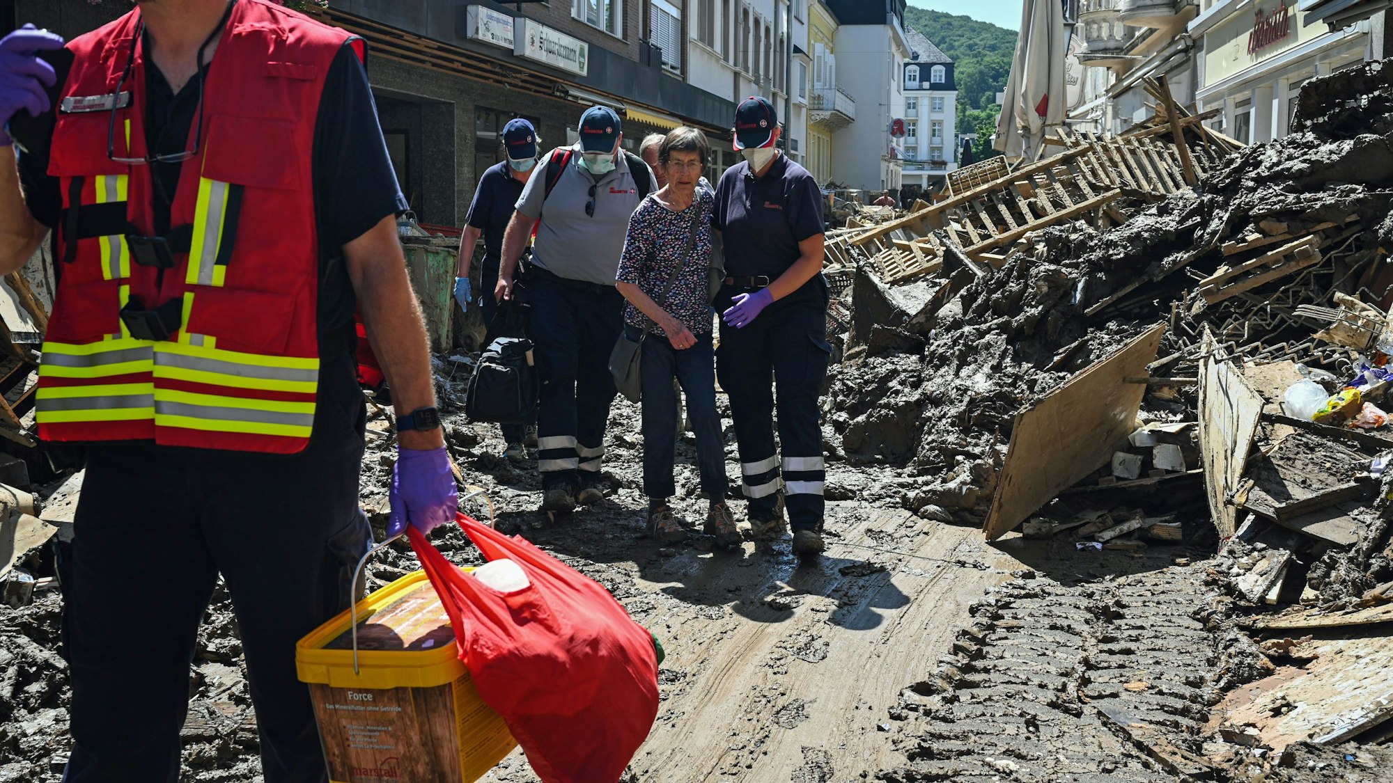 Das Foto vom 12.10.2021 zeigt Helfende der Johanniter in Bad Neuenahr-Ahrweiler, die eine Seniorin kurz nach der Flut-Katastrophe aus ihrer Wohnung begleiten.