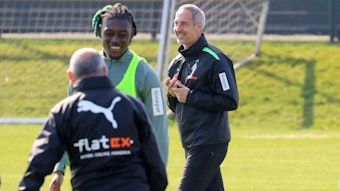 Gute Stimmung im Borussia-Park. Cheftrainer Adi Hütter ist nach überstandener Corona-Infektion wieder auf dem Trainingsplatz. Adi Hütter (r.) lächelt. Manu Kone (l.) lächelt ebenfalls in Richtung der Kamera.