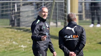Gladbach-Trainer Adi Hütter (l.), hier zu sehen am 22. März 2022, ist nach auskurierter Coronainfektion zurück im Borussia-Park. Hütter spricht mit Co-Trainer Frank Geideck.