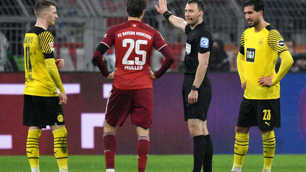 Schiedsrichter Felix Zwayer (2.v.r.) steht im Spiel zwischen Borussia Dortmund neben Marco Reus (l), Emre Can (r) und Münchens Thomas Müller. 