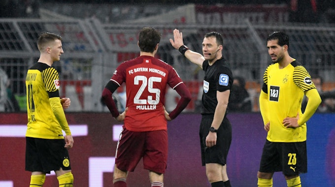 Schiedsrichter Felix Zwayer (2.v.r.) steht im Spiel zwischen Borussia Dortmund neben Marco Reus (l), Emre Can (r) und Münchens Thomas Müller.