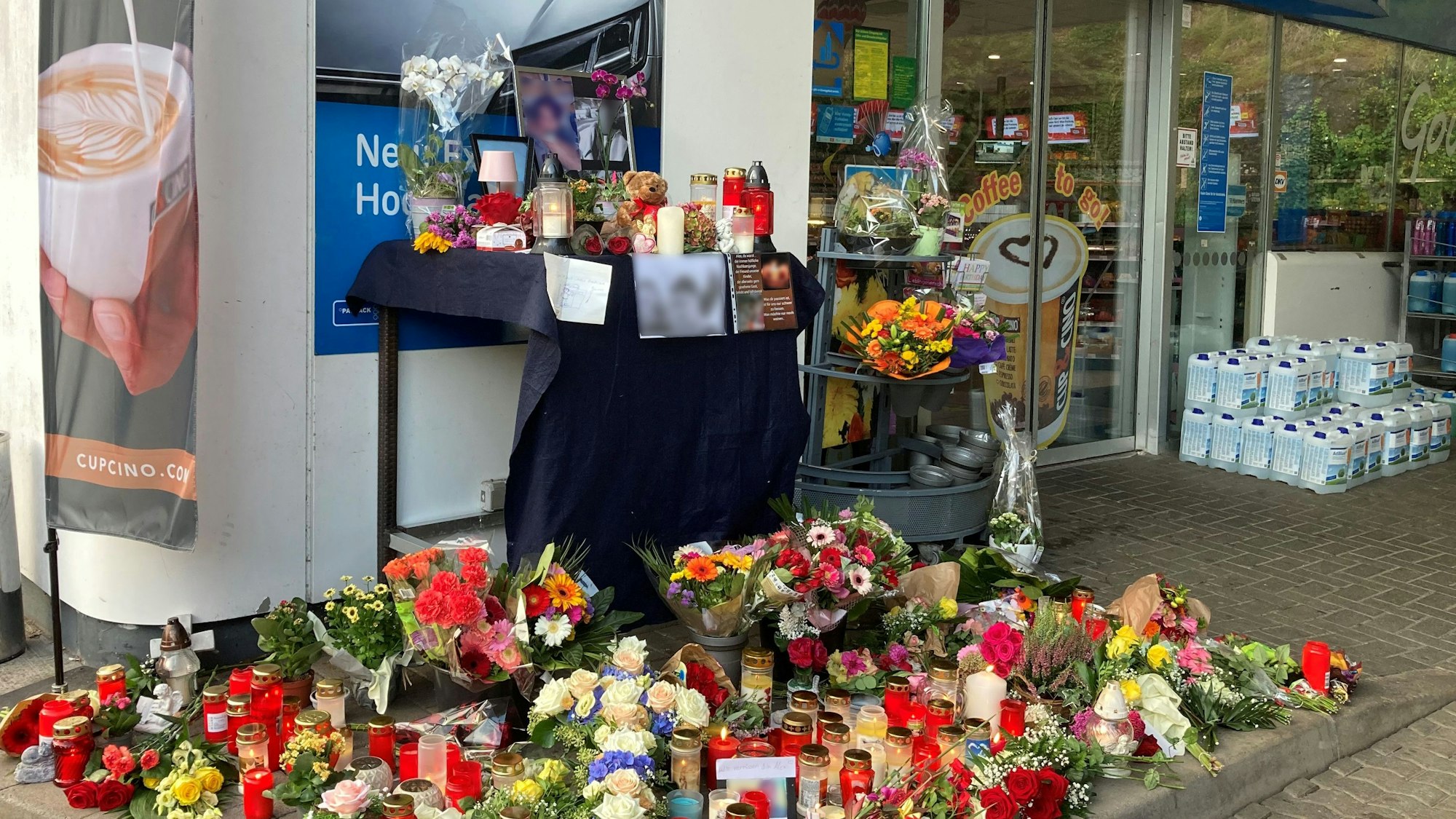 Blumen und Kerzen sind vor einer Tankstelle aufgestellt. Ein Mitarbeiter der Tankstelle war am 18. September von einem Mann erschossen worden.