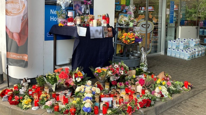 Blumen und Kerzen sind vor einer Tankstelle aufgestellt. Ein Mitarbeiter der Tankstelle war am 18. September von einem Mann erschossen worden.