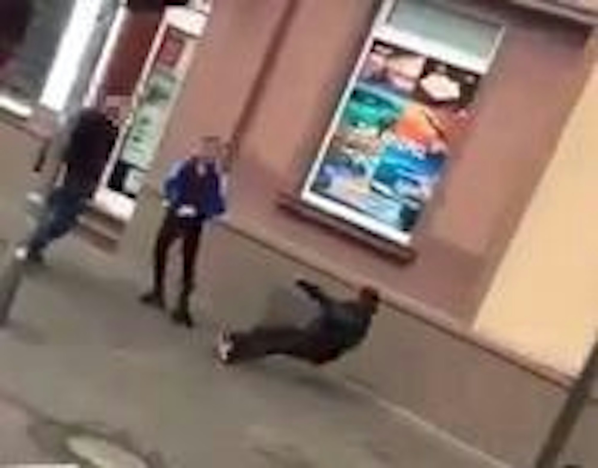 Ein Mann fällt rückwärts zu Boden, zwei Jugendliche stehen vor ihm.