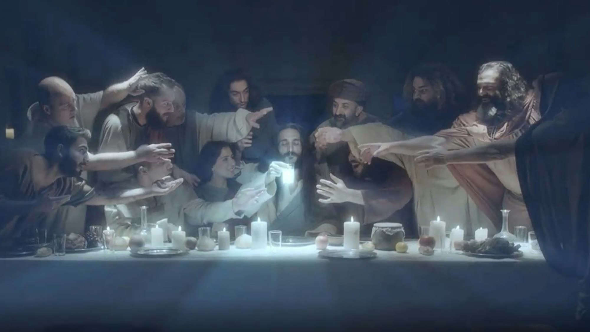 Eine Szene aus dem Video: Jesus hat Wasser und den Raki gemischt und nimmt gleich einen Schluck des milchigen Getränks, das wie eine Er­schei­nung wirkt. Im Werbeclip ist neben den Jüngern auch eine Frau am Tisch.