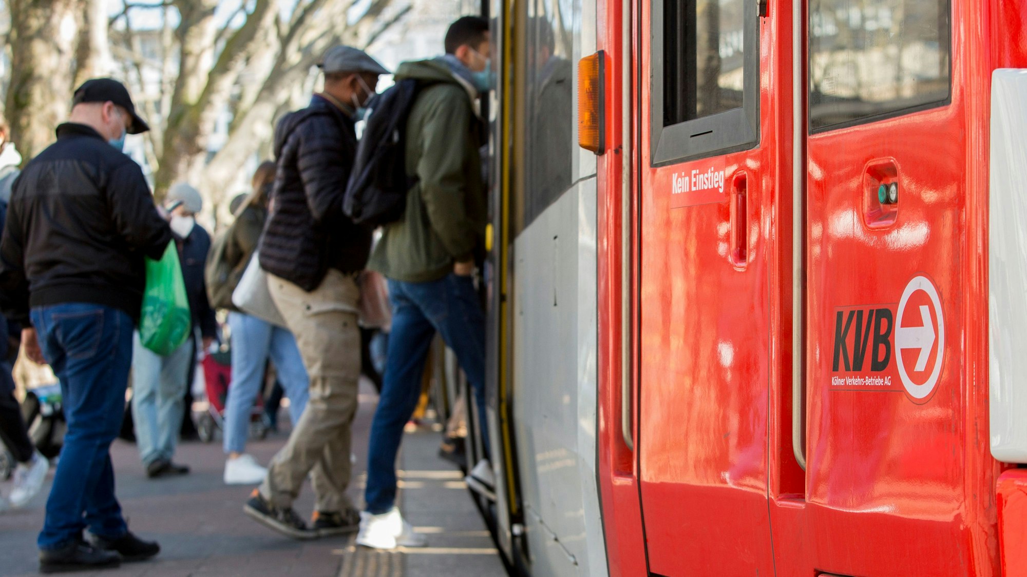 Menschen steigen in Köln in eine Bahn der KVB.
