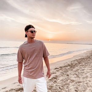 Sänger Julian Sommer steht am Strand auf Mallorca.