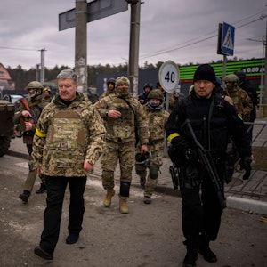 Der ehemalige ukrainische Präsident Petro Poroschenko, umgeben von ukrainischen Soldaten, trifft am 5. März in einer Verteidigungsstellung am Stadtrand von Kyjiw ein.