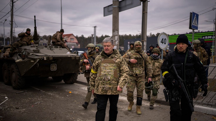 Der ehemalige ukrainische Präsident Petro Poroschenko, umgeben von ukrainischen Soldaten, trifft am 5. März in einer Verteidigungsstellung am Stadtrand von Kyjiw ein.