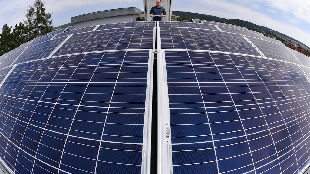 Der Leiter Technik der Wohnungsbaugenossenschaft Fortschritt, Torsten Hoecke, betrachtet am 18.07.2017 in Sondershausen (Thüringen) die Solarpanele auf dem Dach eines Mietshauses.