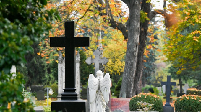 Kreuze und Figuren auf einem Friedhof.