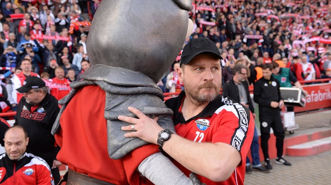 Steffen Baumgart umarmt das Maskottchen von Union Berlin.