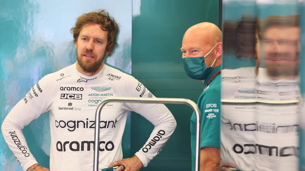 Sebastian Vettel spricht mit einem Teammitglied in der Garage des Aston Martin Teams.