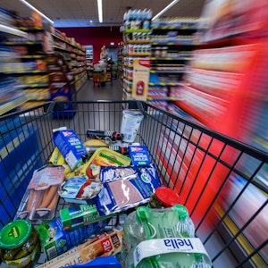 Ein Einkaufswagen mit Lebensmitteln wird am 30. November 2017 in Schwerin (Mecklenburg-Vorpommern) durch die Regalreihen in einem Supermarkt geschoben.