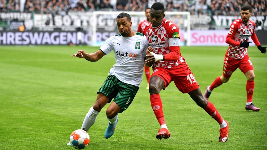 Alassane Plea (l.) von Borussia Mönchengladbach im Zweikampf mit Moussa Niakhaté (r.) von Mainz 05. Die Teams spielen am Sonntag (3. April) am 28. Bundesliga-Spieltag gegeneinander.