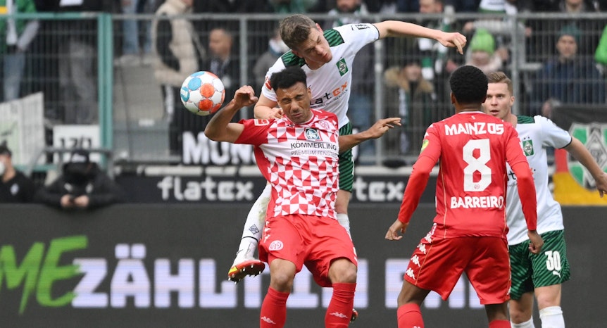 Matthias Ginter von Borussia Mönchengladbach im Luftkampf mit Karim Onisiwo von Mainz 05 im Borussia-Park (3. April 2022).