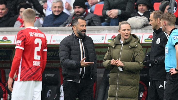 Schiedsrichter Christian Dingert diskutiert mit der Bayern-Bank um Hasan Salihamidzic und Kathleen Krüger.