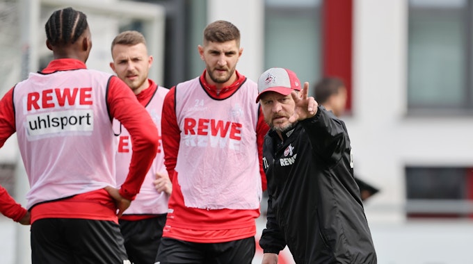 Steffen Baumgart, Trainer des 1. FC Köln, gibt Jeff Chabot, Jannes Horn und Kingsley Ehizibue im Training Anweisungen.