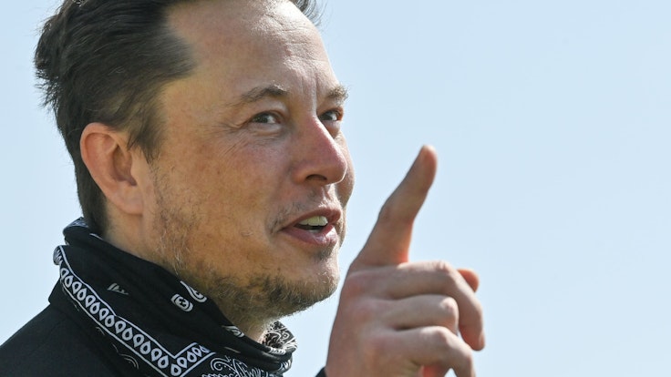 Elon Musk, Tesla-Chef, steht bei einem Pressetermin auf dem Gelände der Tesla Gigafactory und hebt den Finger.