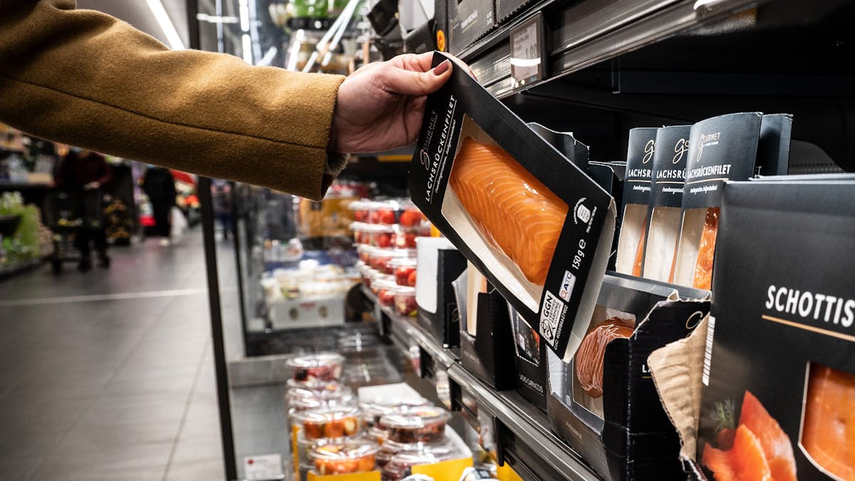 Aldi macht es vor, andere Discounter und Supermärkte werden nachziehen: Die Preise für viele Produkte steigen. Lebensmittel werden immer teurer. Eine Frau nimmt in unserem Archivbild von 2021 in einer Aldi-Filiale ein Produkt aus der Kühlung.