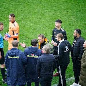 Schiedsrichter Christian Dingert (l in blau) bespricht mit dem vierten Offiziellen sowie Spielern und Verantwortlichen des FC Bayern München sowie des SC Freiburg das Vorgehen.