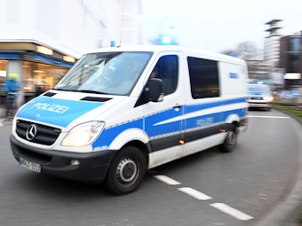 Einsatzfahrzeuge der Polizei fahren am Kölner Neumarkt entlang.