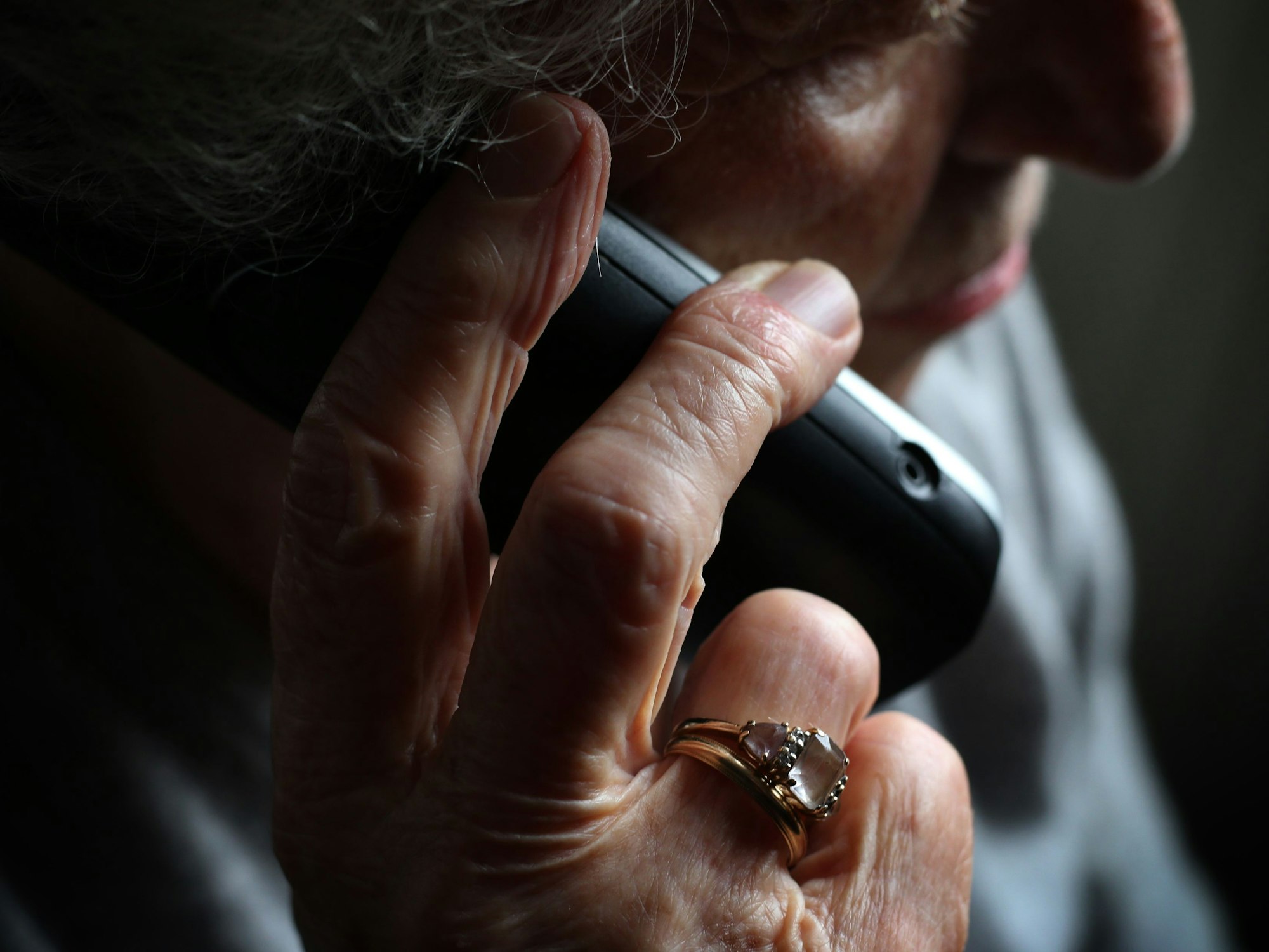 Eine ältere Frau telefoniert mit einem schnurlosen Festnetztelefon.