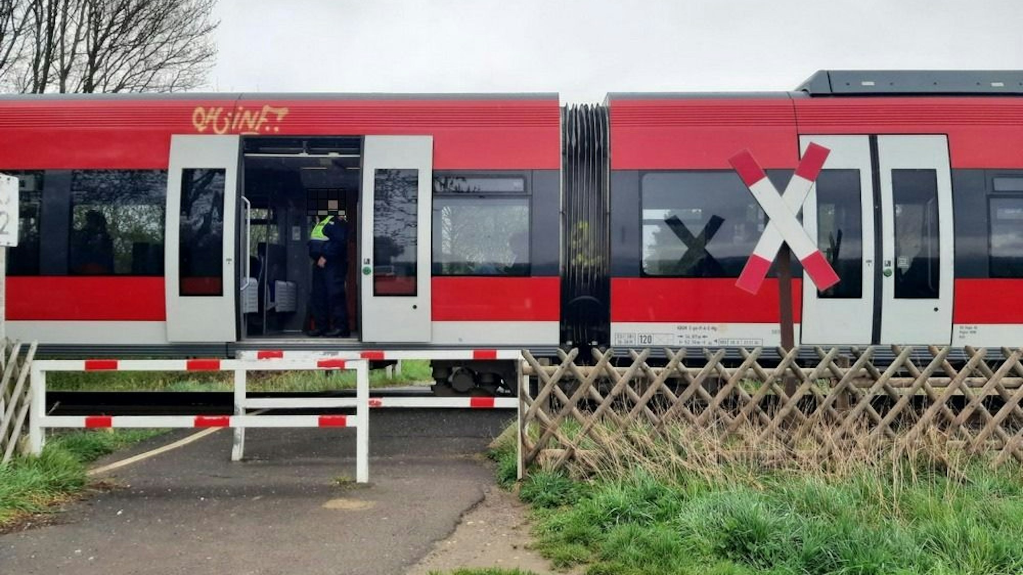 Eine Regionalbahn steht an einem unbeschrankten Bahnübergang in Bergheim.