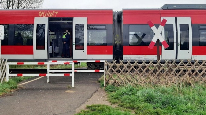 Eine Regionalbahn steht an einem unbeschrankten Bahnübergang in Bergheim.
