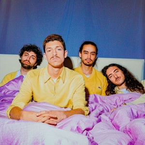 Die Bandmitglieder von Tigermilch posieren im Bett. Mit ihrem eigenen, speziellen Stil erobern die Kölner die Musikwelt.