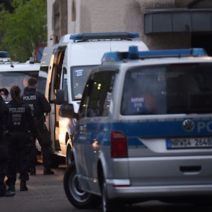 Polizeifahrzeuge und Einsatzkräfte stehen vor einem Kölner Flüchtlingsheim.