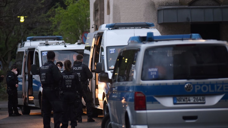 Polizeifahrzeuge und Einsatzkräfte stehen vor einem Kölner Flüchtlingsheim.