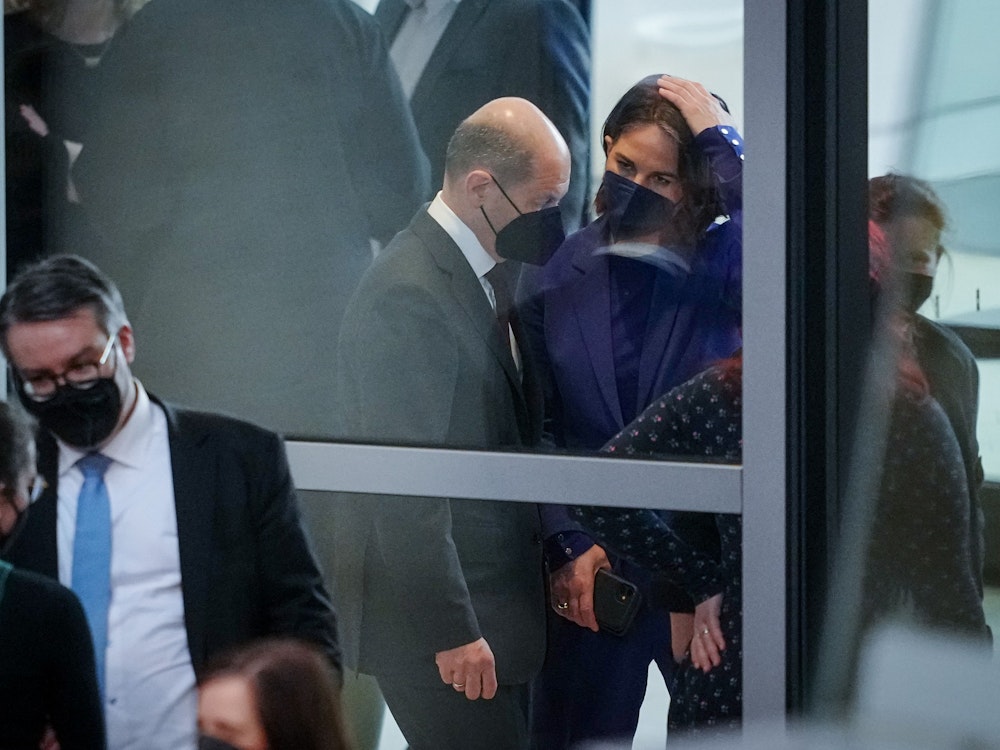 Bundeskanzler Olaf Scholz (SPD) unterhalten sich im Foyer an Rande der Sitzung des Bundestags.