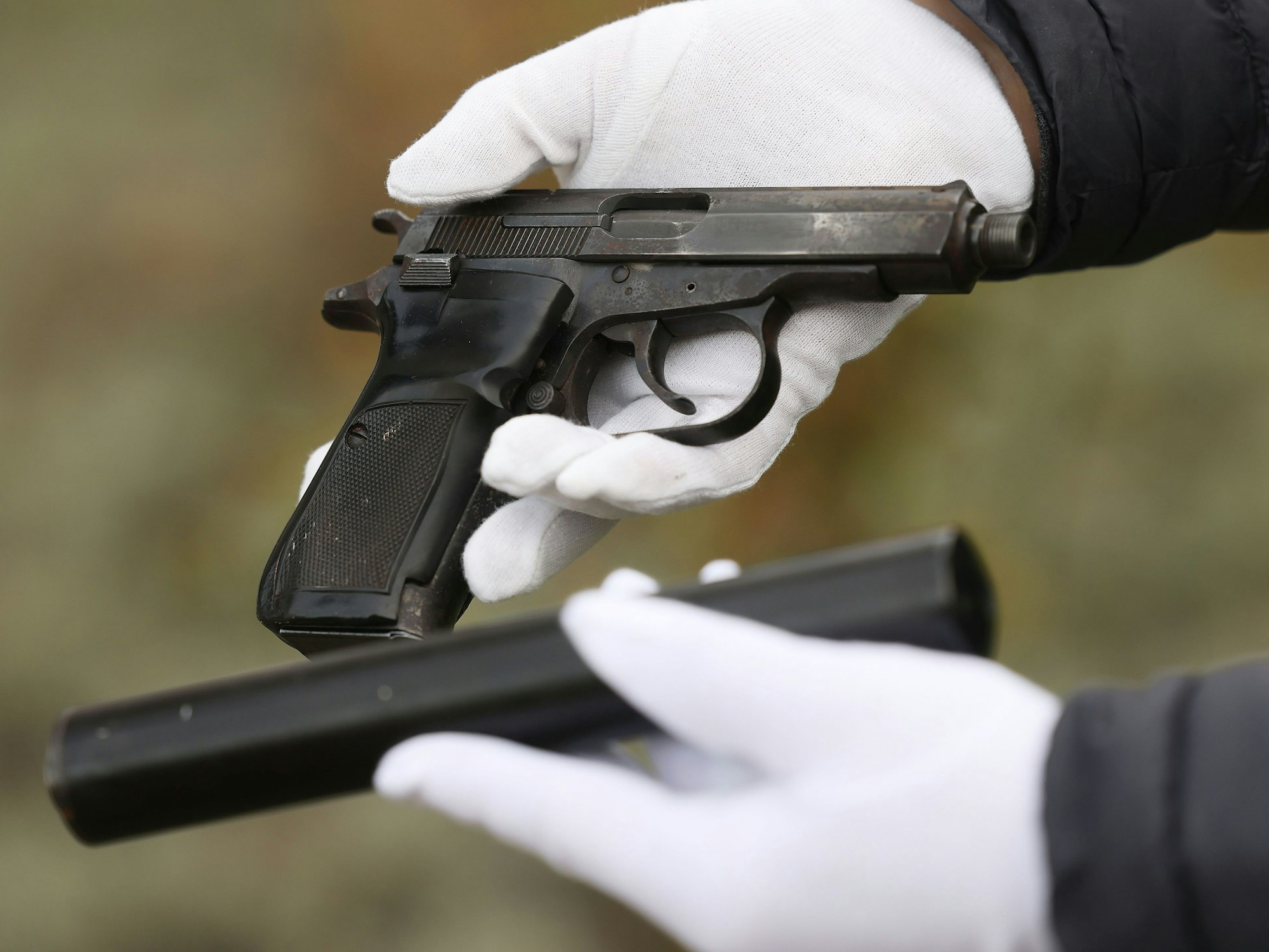 Ein Mitarbeiter des Bundeskriminalamtes hält eine Pistole in der Hand.