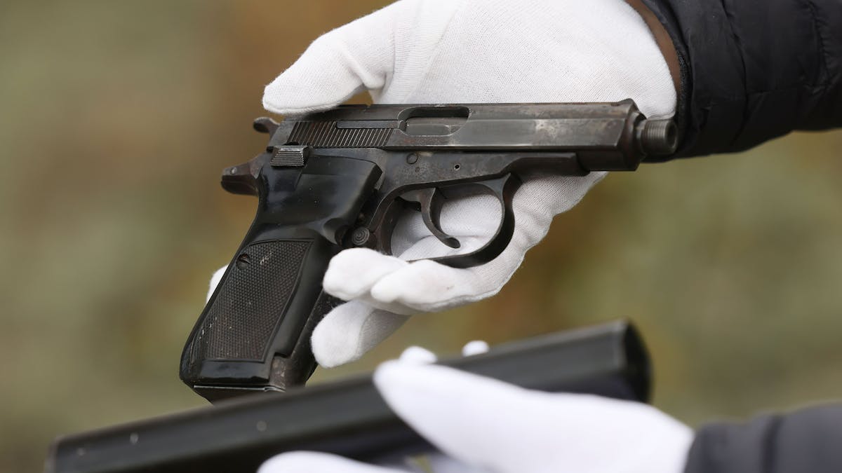 Ein Mitarbeiter des Bundeskriminalamtes hält eine Pistole in der Hand.