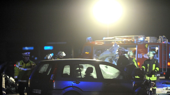 Einsatzkräfte stehen an einem Auto, das auf der Autobahn verunglückt ist.
