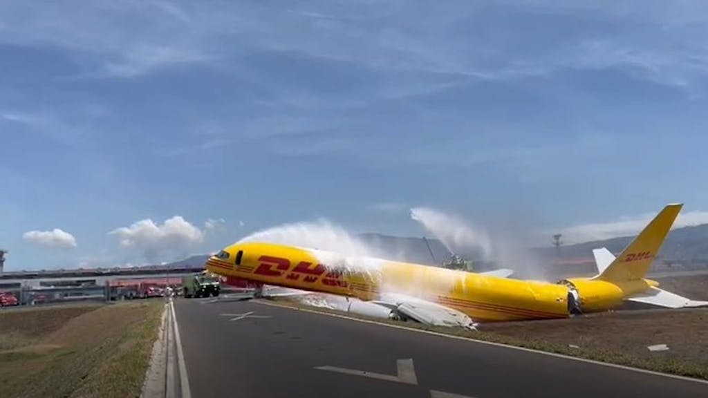 Ein Frachtflugzeug der DHL, das bei der Notlandung auseinandergebrochen war, liegt auf der Landebahn des internationalen Flughafens Juan Santamaria. Die Feuerwehr ist im Einsatz.