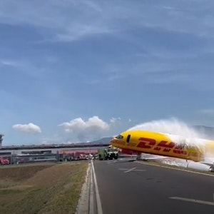 Ein Frachtflugzeug der DHL, das bei der Notlandung auseinandergebrochen war, liegt auf der Landebahn des internationalen Flughafens Juan Santamaria. Die Feuerwehr ist im Einsatz.