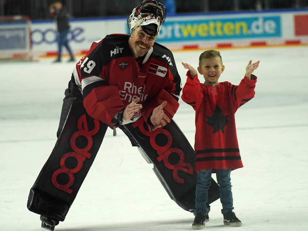 Justin Pogge (Kölner Haie) auf dem Eis mit seinem Kind.