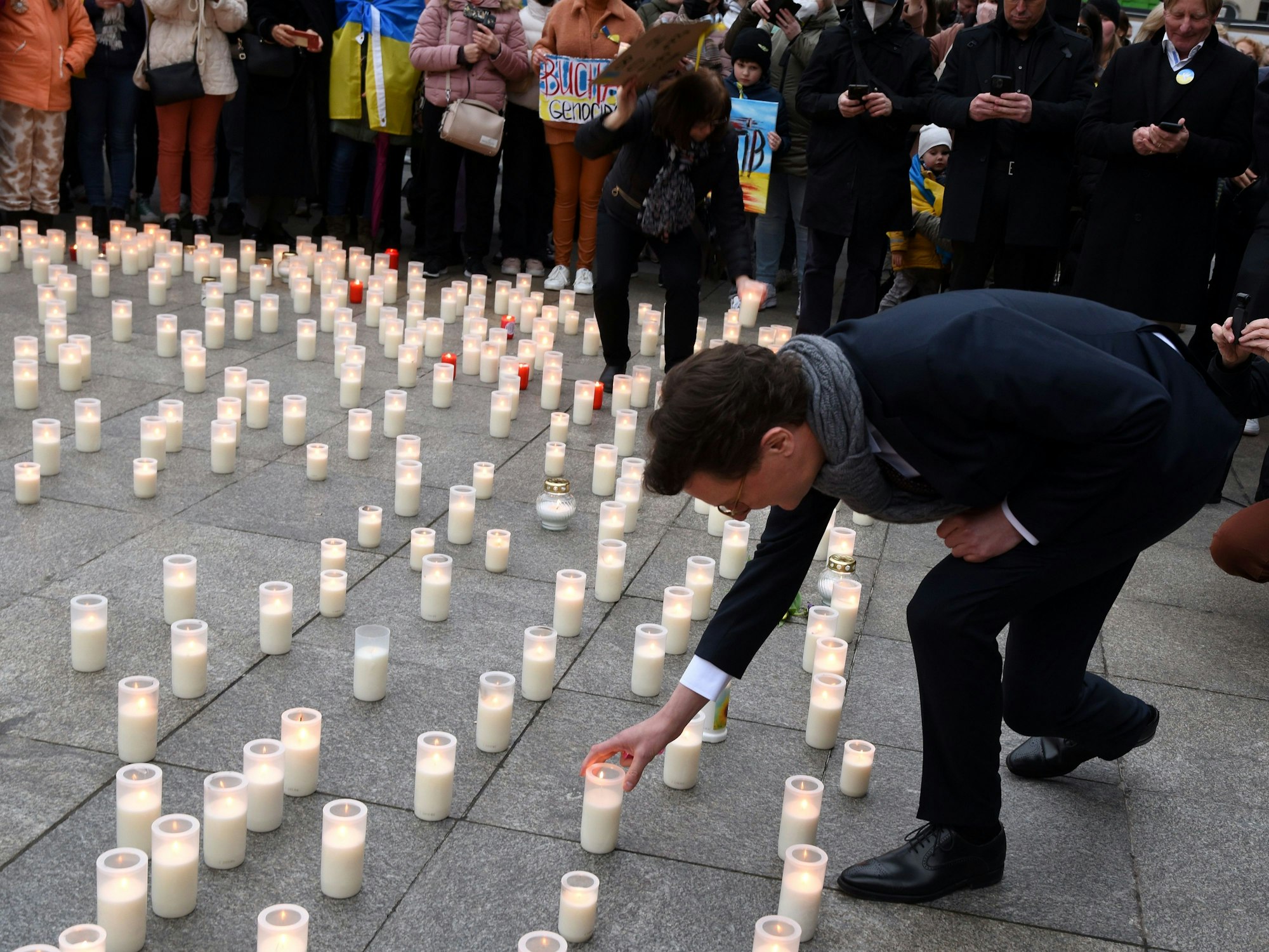NRW-Ministerpräsident Hendrik Wüst


stellt eine Kerze nieder.