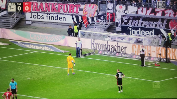 Aktivisten binden sich an den Pfosten des Tores von Eintracht Frankfurt fest.