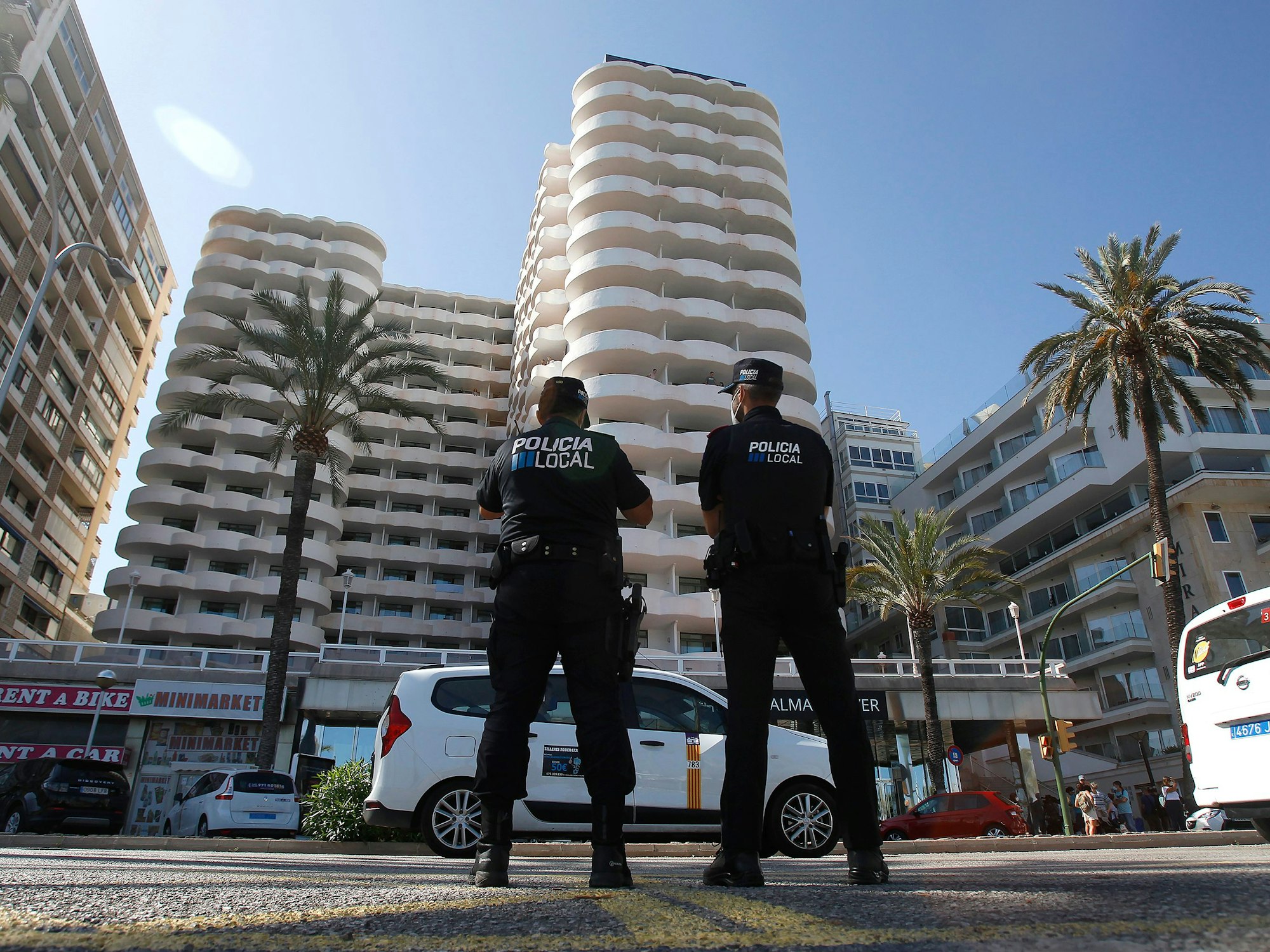 Zwei Polizisten stehen im Einsatz vor einem spanischen Hotel.