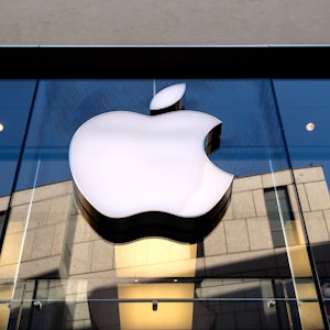 Das Logo des Technologie-Unternehmens Apple ist an einer Gebäudefassade angebracht.
