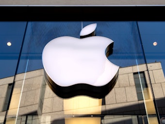 Das Logo des Technologie-Unternehmens Apple ist an einer Gebäudefassade angebracht.