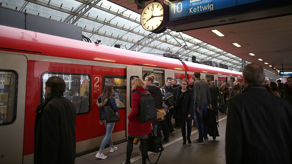 Fahrgäste stehen am Hauptbahnhof Köln vor einer S-Bahn
