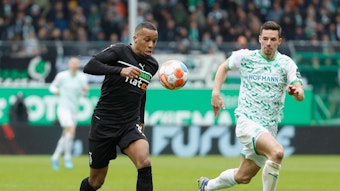 Stürmer Alassane Plea von Borussia Mönchengladbach im Laufduell mit Nick Viergever von Greuther Fürth am 09. April 2022. Plea hat den Ball.